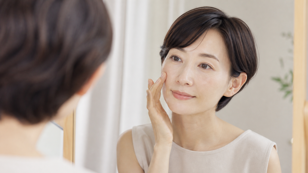 鏡で頬や鼻の毛穴の見え方を確認する女性